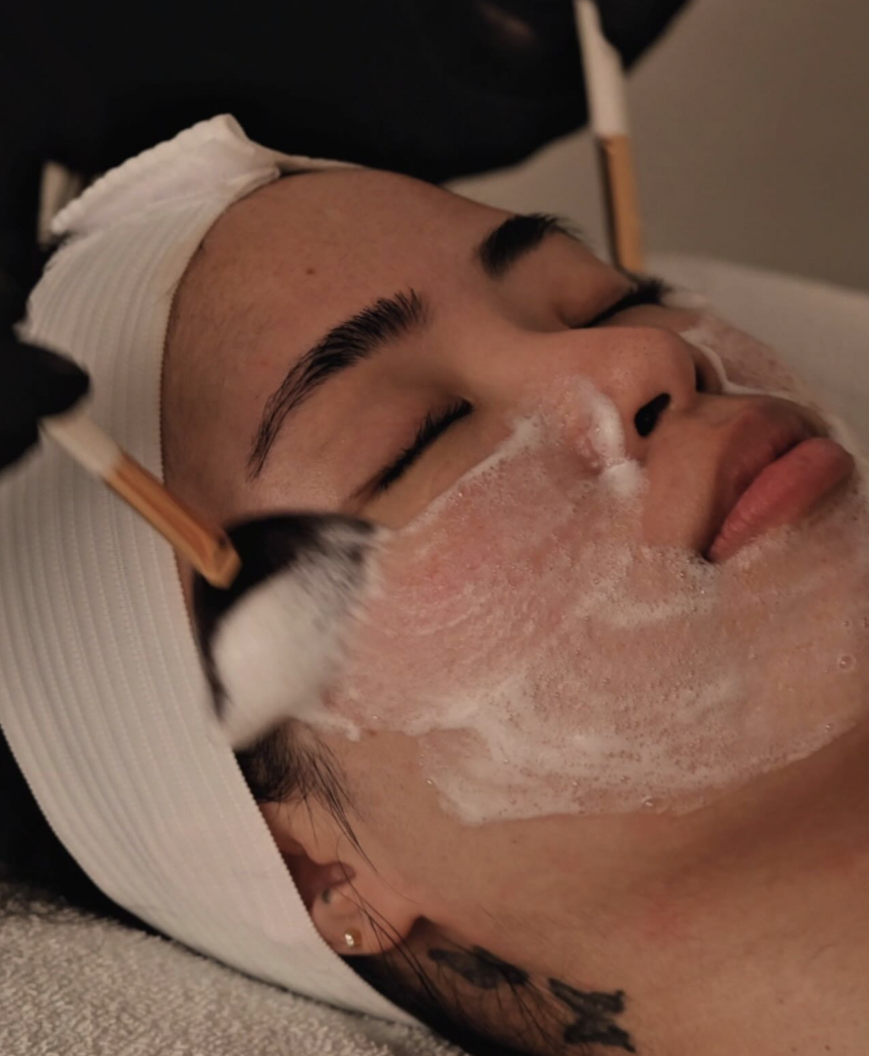 Client receiving a professional facial with a foaming cleanser at LUX Beauty Bar in Grimsby.