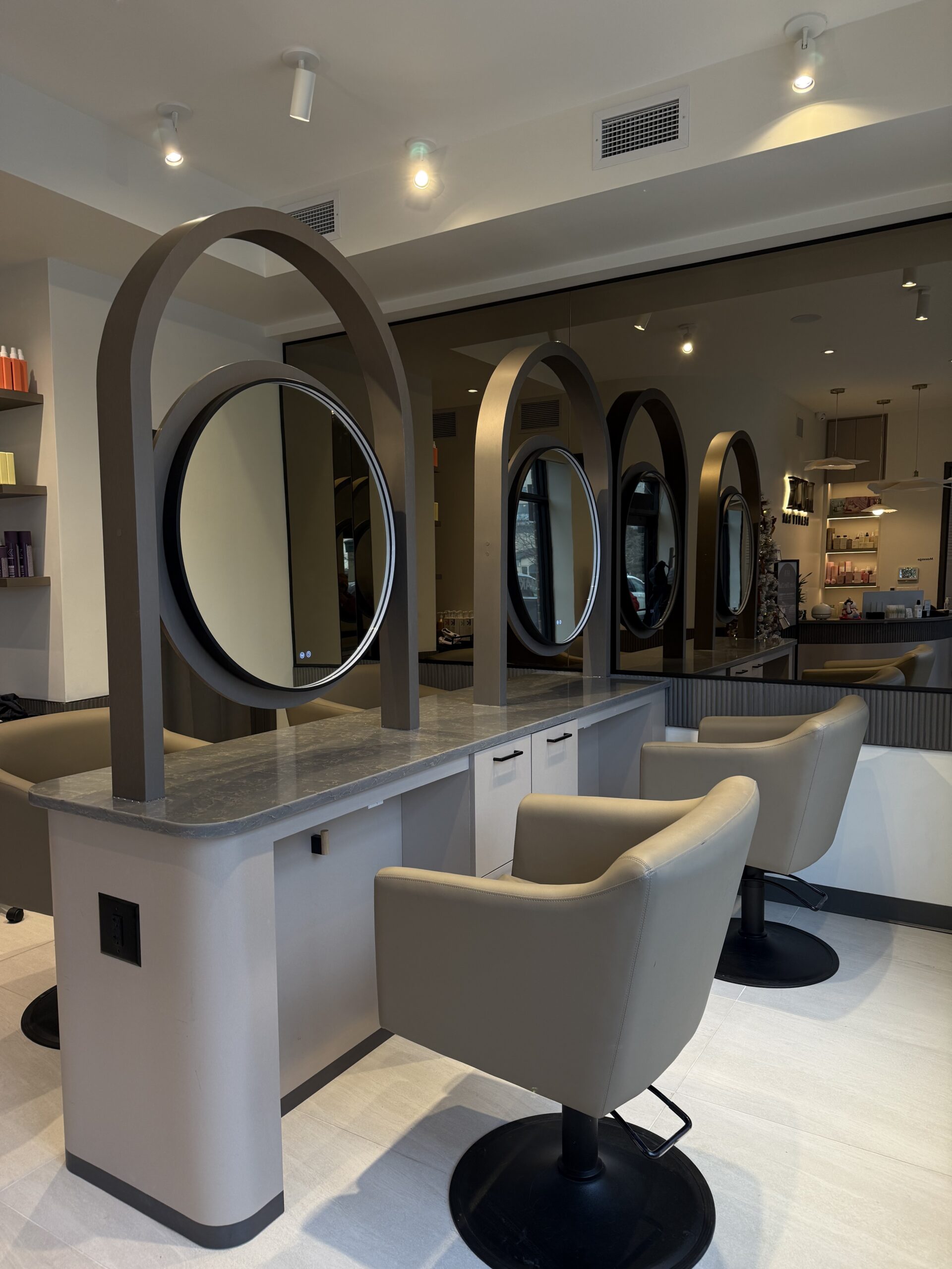 Interior of LUX Beauty Bar Hair Spa in Grimsby with styling chairs and circular mirrors.