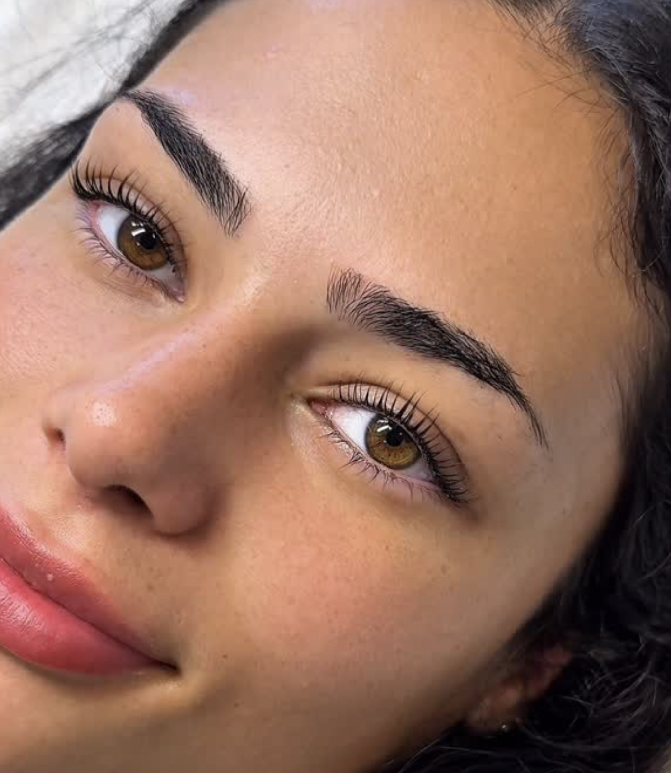 Client showcasing a lash lift and professionally shaped brows at LUX Beauty Bar.