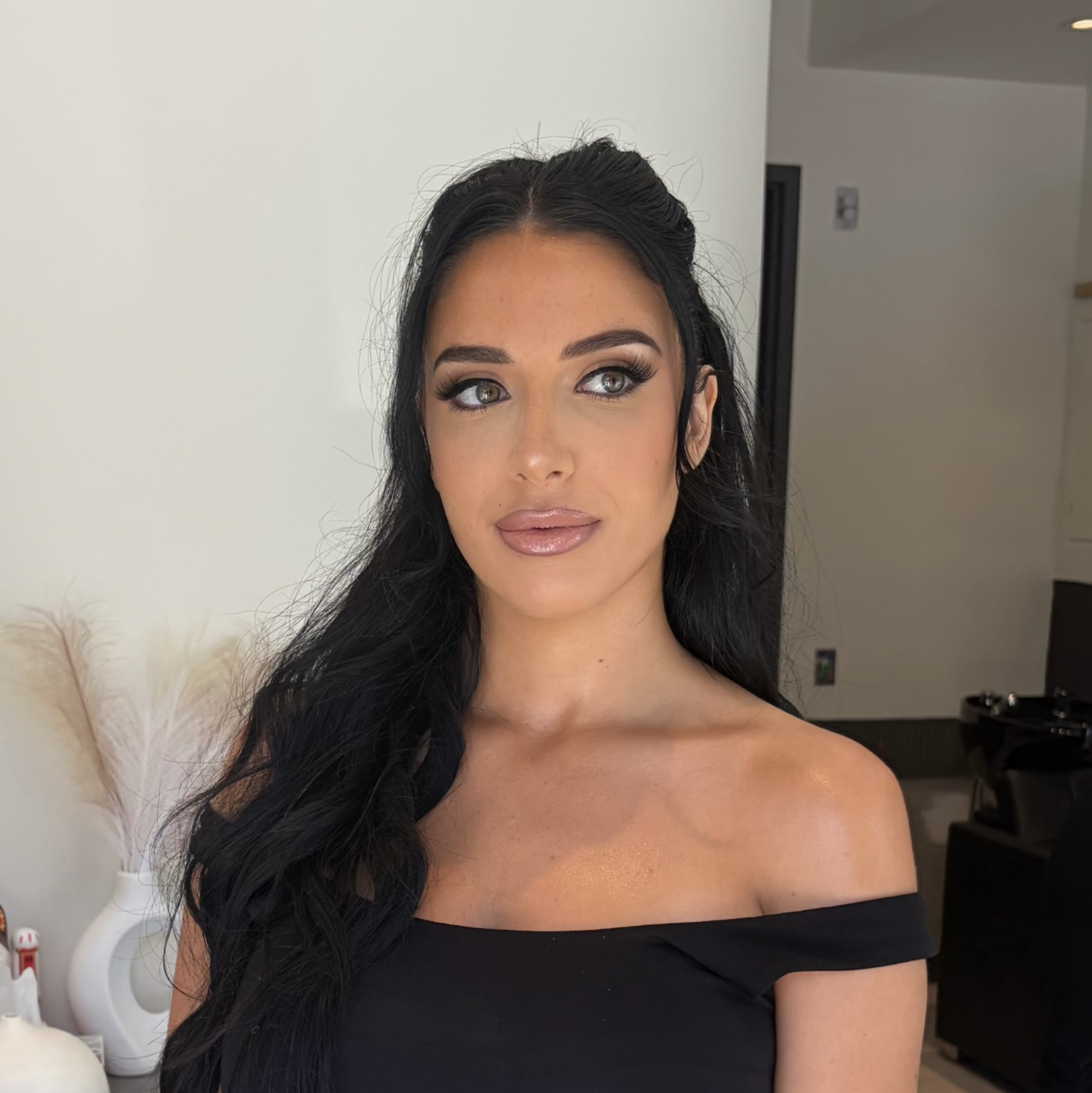 Client with professional soft-glam makeup, winged eyeliner and glossy nude lips at LUX Beauty Bar.